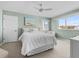 Bright bedroom with a large window, ceiling fan, beach-themed decor, and comfortable bed and chair seating at 911 Harbour House Dr, Indian Rocks Beach, FL 33785
