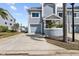 Light blue townhome with a one-car garage, front porch, and long driveway at 911 Harbour House Dr, Indian Rocks Beach, FL 33785