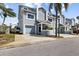 Charming townhouse with light-blue siding, well-manicured landscaping, and a private garage at 911 Harbour House Dr, Indian Rocks Beach, FL 33785