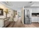 Open-concept kitchen with stainless steel refrigerator and easy access to stairs at 911 Harbour House Dr, Indian Rocks Beach, FL 33785