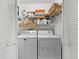 Convenient laundry area with a modern washer and dryer, folding space, storage cabinets, and louvered closet doors at 911 Harbour House Dr, Indian Rocks Beach, FL 33785
