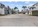 A residential street showcasing well-maintained townhomes with lush landscaping and ample parking at 911 Harbour House Dr, Indian Rocks Beach, FL 33785