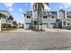 Three light blue townhomes, each with a one-car garage and an ample driveway at 911 Harbour House Dr, Indian Rocks Beach, FL 33785