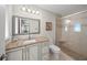 The renovated bathroom has a marble vanity, framed mirror, and tiled shower with glass doors at 931 Inlet Cir, Venice, FL 34285