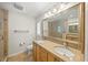 Bright bathroom with double sink vanity, granite counters, and a walk-in shower with glass enclosure at 931 Inlet Cir, Venice, FL 34285