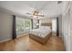 Comfortable bedroom with hardwood floors, closet, ceiling fan, and large window views at 931 Inlet Cir, Venice, FL 34285