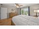 Cozy bedroom with wood floors, window, dresser, and ceiling fan at 931 Inlet Cir, Venice, FL 34285