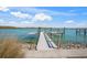This waterfront dock features a boat lift, with calm water and a beautiful view of the surrounding neighborhood at 931 Inlet Cir, Venice, FL 34285