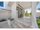 Inviting front porch with tiled floors, white railing, and double glass doors at 931 Inlet Cir, Venice, FL 34285