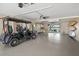 Spacious garage features epoxy floors, high ceilings, a golf cart, storage, and access to the back patio at 931 Inlet Cir, Venice, FL 34285