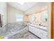 Well-lit bathroom with a soaking tub, tiled walls, double sink vanity with storage, and recessed lighting at 9718 Lomalinda Ct, New Port Richey, FL 34655