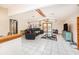 Spacious living room featuring vaulted ceilings, a cozy black sectional, and a glass coffee table at 9718 Lomalinda Ct, New Port Richey, FL 34655