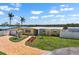 Charming yellow home with a well-manicured lawn, brick walkway, and lush landscaping at 109 Carmelina St, Ruskin, FL 33570