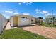 Charming yellow home with attached garage and circular brick driveway, featuring a white fence at 109 Carmelina St, Ruskin, FL 33570
