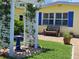 Charming yellow home featuring a seating area on the front patio at 109 Carmelina St, Ruskin, FL 33570