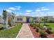 Charming yellow waterfront home featuring a brick walkway and manicured landscaping at 109 Carmelina St, Ruskin, FL 33570