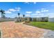 Charming yellow home with a brick driveway, palm trees, a blue door, and well-maintained lawn at 109 Carmelina St, Ruskin, FL 33570