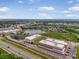 An aerial view shows the commercial buildings, parking, lake, and surrounding community at 11109 Great Neck Rd, Riverview, FL 33578