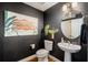 Stylish powder room features wood flooring, art, and modern decor at 11109 Great Neck Rd, Riverview, FL 33578