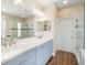 Elegant bathroom features a double sink vanity, a glass shower, and wood-look flooring at 11109 Great Neck Rd, Riverview, FL 33578