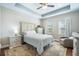 Comfortable bedroom features a tray ceiling, ceiling fan, and stylish furniture at 11109 Great Neck Rd, Riverview, FL 33578