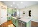 Bright kitchen features stainless appliances, island with barstool seating, and green cabinetry at 11109 Great Neck Rd, Riverview, FL 33578