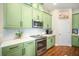 Bright kitchen features stainless appliances and stylish green cabinetry at 11109 Great Neck Rd, Riverview, FL 33578