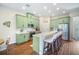 Bright kitchen features stainless appliances, island with barstool seating, and green cabinetry at 11109 Great Neck Rd, Riverview, FL 33578
