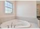 Corner soaking tub with a window for natural light at 1161 Rio De Janeiro Ave, Punta Gorda, FL 33983