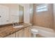 The bathroom features a granite vanity and a tub and shower with beige tile at 1161 Rio De Janeiro Ave, Punta Gorda, FL 33983