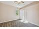 This carpeted bedroom shows a ceiling fan, bright window, base trim and a closet with doors at 1161 Rio De Janeiro Ave, Punta Gorda, FL 33983