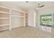 Bright living room featuring custom built-in shelves, tile flooring, and sliding glass doors to the pool area at 1161 Rio De Janeiro Ave, Punta Gorda, FL 33983