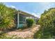 A brick path leads to the house, framed by lush landscaping and tropical foliage at 1161 Rio De Janeiro Ave, Punta Gorda, FL 33983