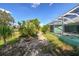 A brick path is surrounded by greenery and rocks leads to the back yard pool area at 1161 Rio De Janeiro Ave, Punta Gorda, FL 33983