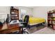Cozy bedroom with a desk, bookcase, and yellow blanket on the bed at 13110 Shumard Way, Riverview, FL 33579