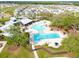 Aerial view of community pool featuring a splash pad, lane pool, clubhouse, and green space at 13110 Shumard Way, Riverview, FL 33579