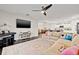Cozy living room featuring a large sectional sofa, ceiling fan, and open layout to the kitchen at 13110 Shumard Way, Riverview, FL 33579