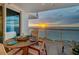 Balcony with dining table overlooking the ocean and sunset views, perfect for entertaining at 1350 Gulf Blvd # 502, Clearwater Beach, FL 33767