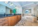 Bathroom featuring double sink vanity, granite countertop, and a luxurious soaking tub at 1350 Gulf Blvd # 502, Clearwater Beach, FL 33767