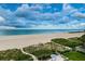 Stunning beach view from the property overlooking white sand and turquoise water under a blue, cloudy sky at 1350 Gulf Blvd # 502, Clearwater Beach, FL 33767