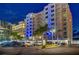 Exterior shot of the Utopia condo complex at night, with illuminated blue accents and palm trees at 1350 Gulf Blvd # 502, Clearwater Beach, FL 33767
