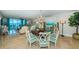 Elegant dining room with chandelier and seating, with an adjacent living room with ocean view at 1350 Gulf Blvd # 502, Clearwater Beach, FL 33767
