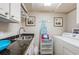Efficient laundry room with granite counters, a sink, a washer/dryer, and ample storage space at 1350 Gulf Blvd # 502, Clearwater Beach, FL 33767