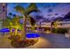 Relaxing pool and spa area at twilight, surrounded by lush greenery, lounge chairs, and ambient lighting at 1350 Gulf Blvd # 502, Clearwater Beach, FL 33767
