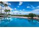 Stunning pool area with lounge chairs, umbrellas, lush greenery, and access to a beautiful beach at 1350 Gulf Blvd # 502, Clearwater Beach, FL 33767