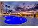 Inviting pool at dusk, surrounded by palm trees, lounge chairs, and a relaxing beachfront view at 1350 Gulf Blvd # 502, Clearwater Beach, FL 33767