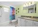 Bathroom featuring a granite countertop vanity, decorative shower curtain and standard shower-tub combo at 1508 Eden Isle Ne Blvd, St Petersburg, FL 33704