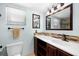 Well lit bathroom featuring a large mirror above a brown wood cabinet and dark fixtures at 1508 Eden Isle Ne Blvd, St Petersburg, FL 33704