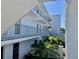 Exterior of the condo featuring white facade, metal railings and lush tropical landscaping at 1655 S Highland Ave # I286, Clearwater, FL 33756