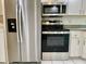 Kitchen with stainless steel refrigerator, microwave, oven, and plenty of cabinet storage at 1655 S Highland Ave # I286, Clearwater, FL 33756